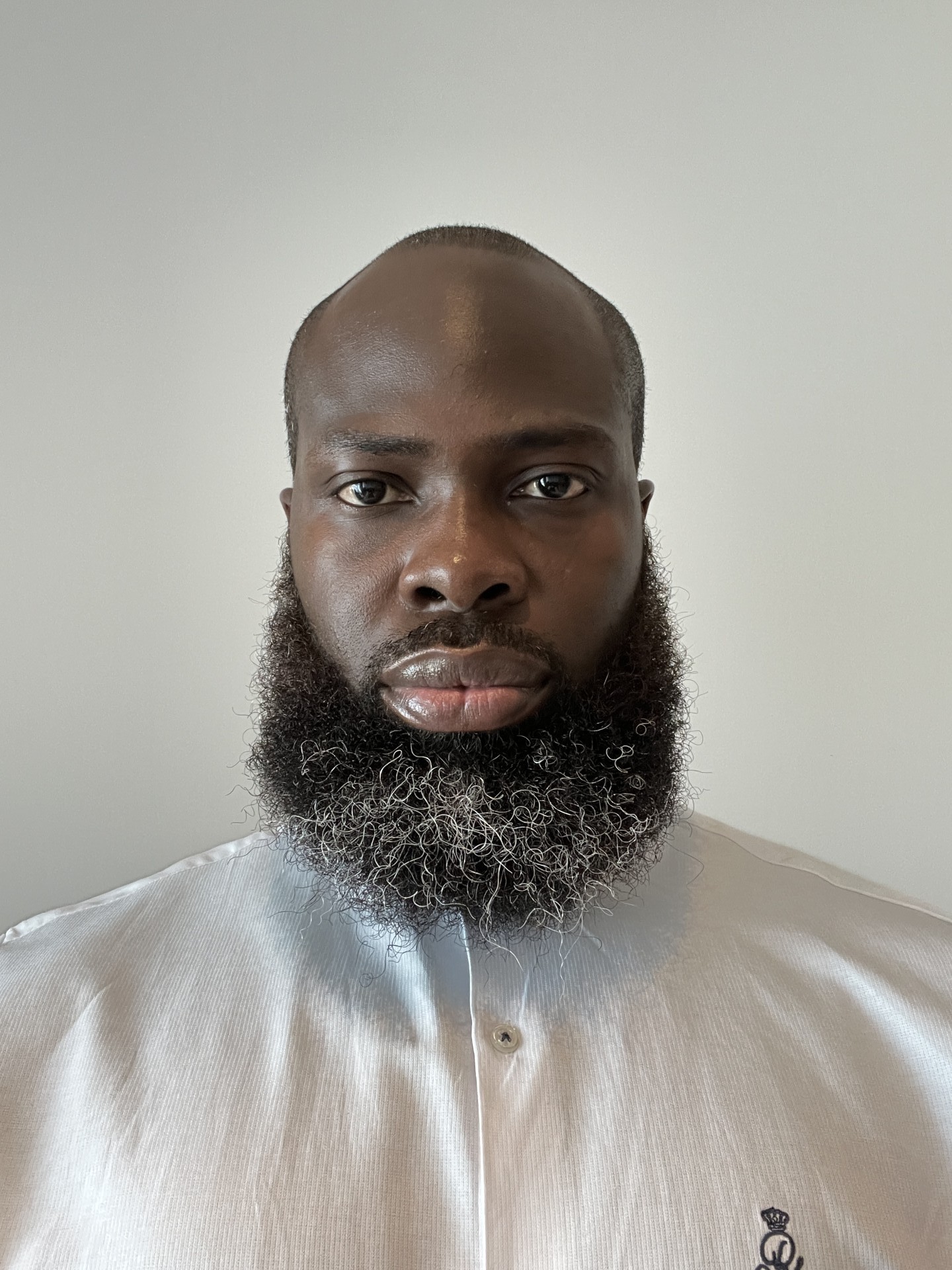 Ulriche looked at the camera in a white shirt and a white background.