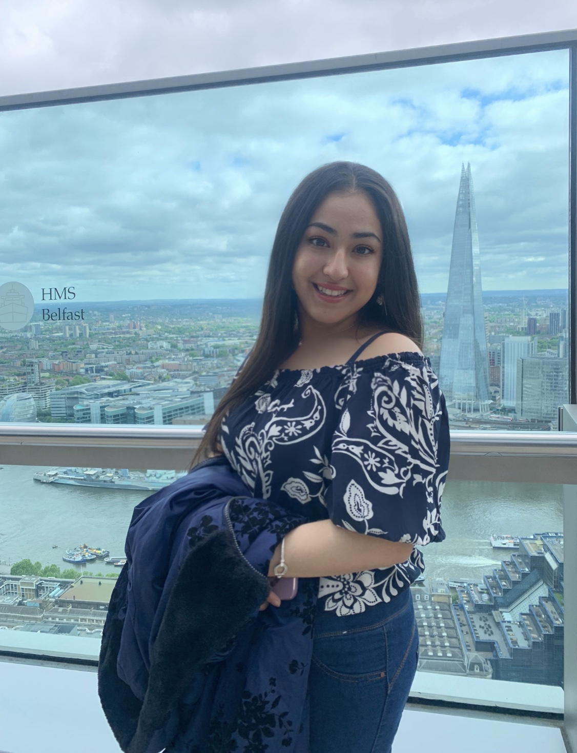 Archisha TEL Student Ambassador holding her jacket. Smiling and looking at the camera.