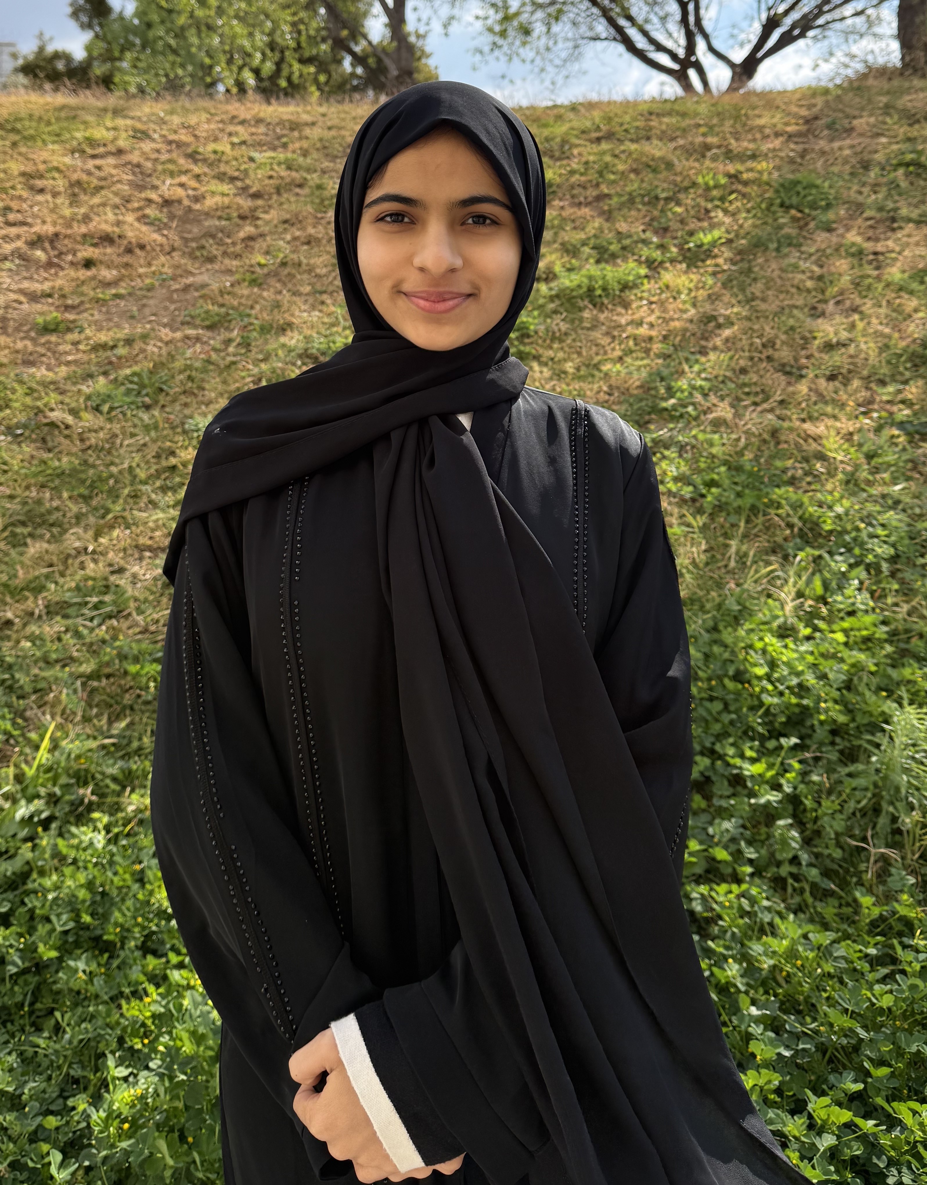 Hayat TEL Ambassador looking at the camera. There is grass behind them.