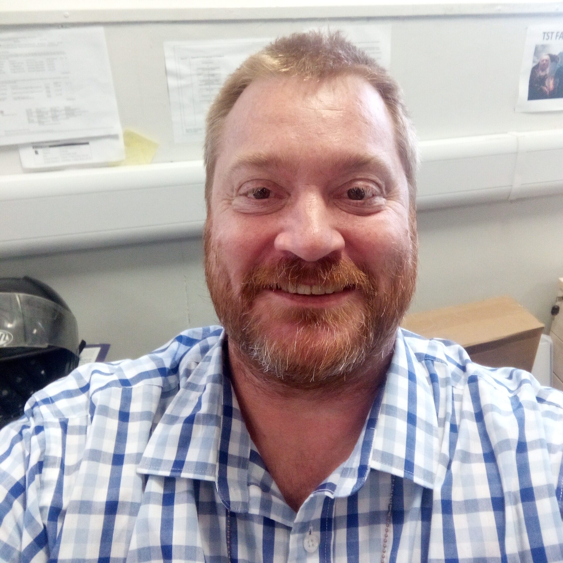 Steve Brant wearing a blue and white shirt looking at the camera smiling.