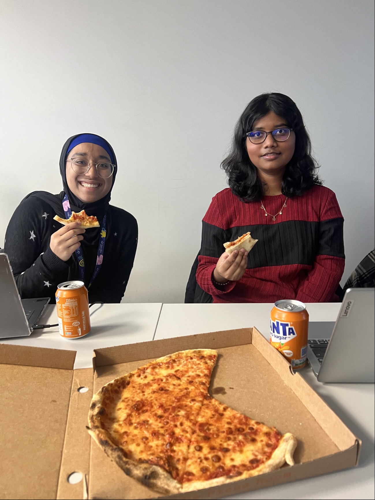 Student sitting at the session, eating pizza.