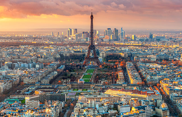 The skyline of Paris with the Eiffel Tower at the forefront and the skyscrapers of La Défense in the background.